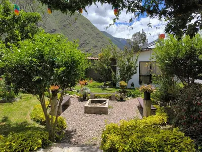 a garden with a bench and a table and trees at The Willow B&B in Urubamba