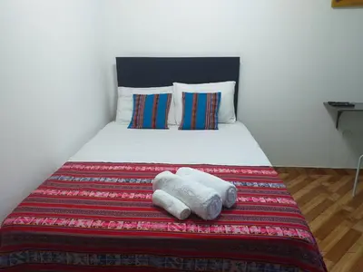 a bedroom with a bed with two towels on it at Chakana Family Home 2 Lima Airport in Lima