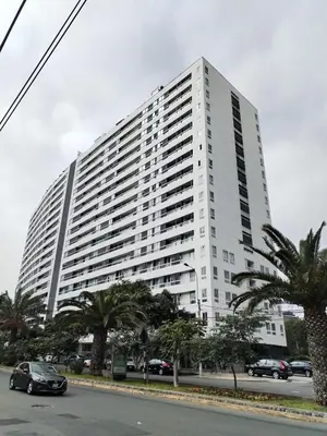a large white building with palm trees in front of it at MLA apartments - Reducto 360 in Lima