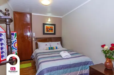 a bedroom with a bed with two hats on it at Kametza Hotel Ayacucho in Ayacucho