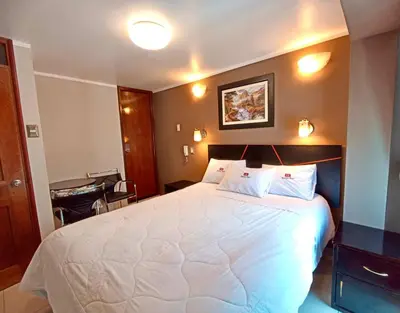 a bedroom with a large white bed with two pillows at Kametza Hotel Ayacucho in Ayacucho