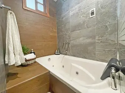 a bathroom with a white tub and a shower at Town Center Apartments in Urubamba