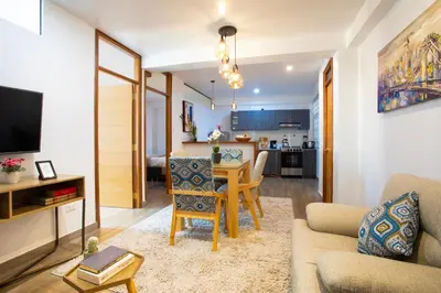 a living room with a table and a dining room at Town Center Apartments in Urubamba