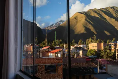 a view of a city from a window with mountains at Town Center Apartments in Urubamba