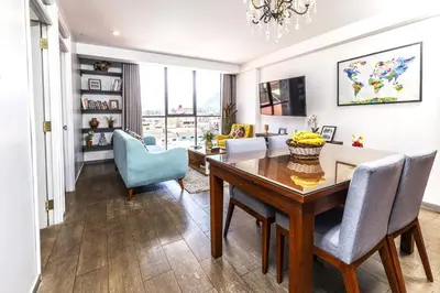 a dining room and living room with a table and chairs at Town Center Apartments in Urubamba