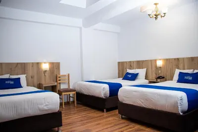 a hotel room with two beds and a chandelier at Estancia San Pedro Hotel in Cusco