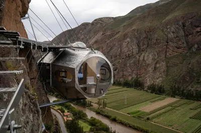 a gondola flying over a river in a mountain at Starlodge Adventure Suites in Urubamba