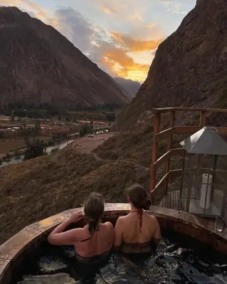 two women are sitting in a bath tub in the mountains at Starlodge Adventure Suites in Urubamba