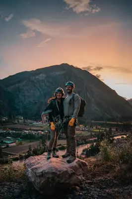 a man and woman standing on a rock in front of a mountain at Starlodge Adventure Suites in Urubamba