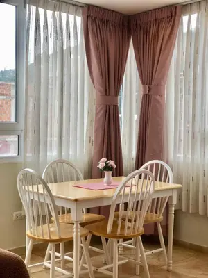 a dining room table with four chairs and a vase of flowers on it at Chanka Suites in Talavera