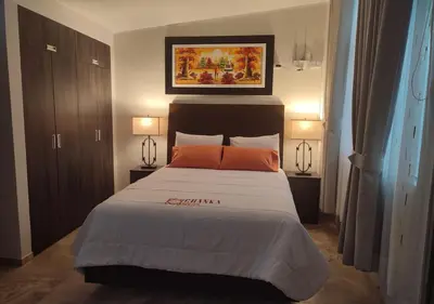 a bedroom with a large bed with two lamps at Chanka Suites in Talavera