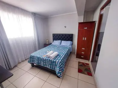a bedroom with a bed with a blue and white blanket at Residencia Benavides in San Vicente de Cañete
