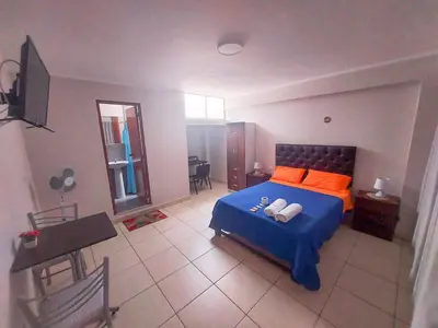 a bedroom with a blue bed with orange pillows at Residencia Benavides in San Vicente de Cañete