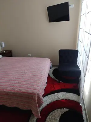 a bedroom with a bed and a blue chair at Apartamento JATUN MAMA in Chancay