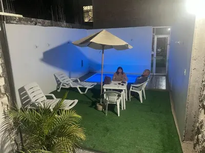 two people sitting at a table under an umbrella at La Petite Maison in Nazca