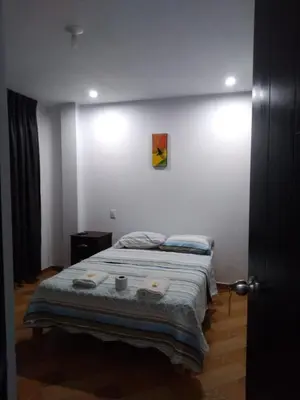 a bedroom with a bed and a picture on the wall at La Petite Maison in Nazca