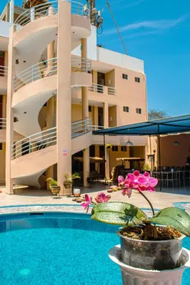 a building with a pool and a flower in a pot at DEL VALLE HOUSE II in Ica