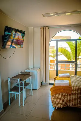 a room with a bed and a desk and a table at DEL VALLE HOUSE II in Ica