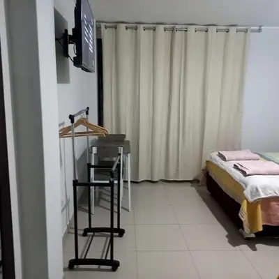 a room with a bed and a television and a table at DEL VALLE HOUSE II in Ica