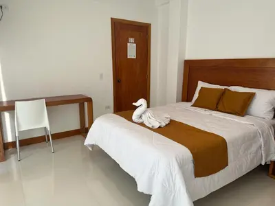 a white duck sitting on a bed in a bedroom at Hotel Overland in Paracas