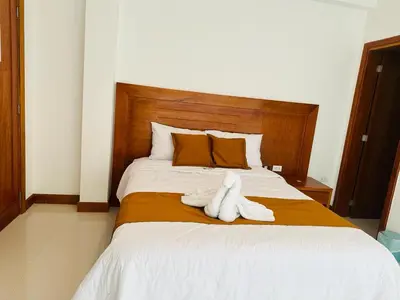 a bed with two white towels on top of it at Hotel Overland in Paracas