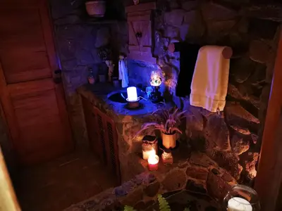a stone bathroom with a candle and a sink at Villa Celestial in Nieve Nieve