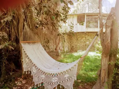 a hammock hanging from a tree in a garden at Villa Celestial in Nieve Nieve