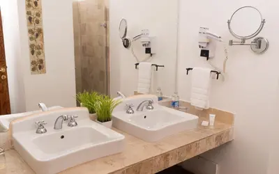 a bathroom with two sinks and a mirror at Hotel Viñas Queirolo in Ica