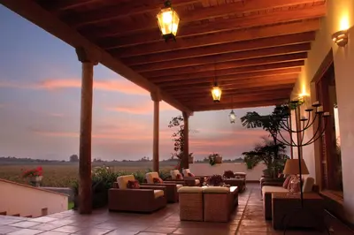 a patio with couches and chairs on a building at Hotel Viñas Queirolo in Ica