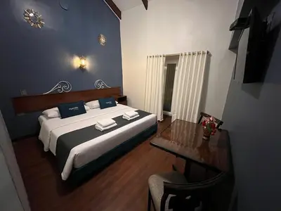 a bedroom with a large bed and a table at Hotel Andina in Cusco
