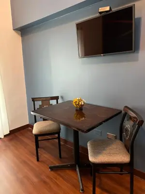 a table with two chairs and a television on a wall at Hotel Andina in Cusco