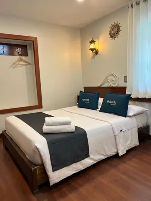 a bedroom with a large bed with blue pillows at Hotel Andina in Cusco