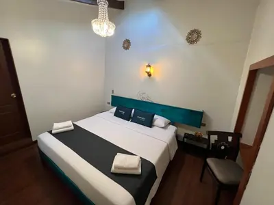 a bedroom with a bed and a chandelier at Hotel Andina in Cusco