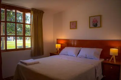 a bedroom with a bed with two lamps and a window at Casa Solaris in Ica