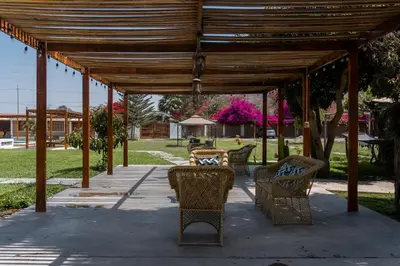 a wooden pavilion with chairs and tables in a park at Casa Solaris in Ica