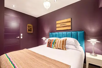 a bedroom with purple walls and a bed with a blue headboard at ✶ Maras Residence ✶ LUXURY Rooftop Pool & Grill in Lima