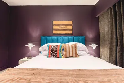 a bedroom with a large bed with a blue headboard at ✶ Maras Residence ✶ LUXURY Rooftop Pool & Grill in Lima