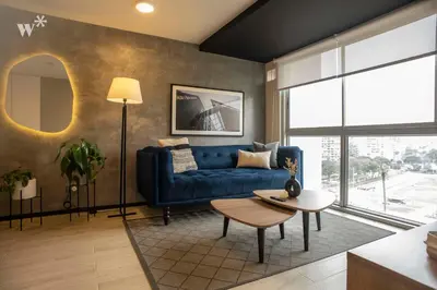 a living room with a blue couch and a table at Pionero by Wynwood House in Lima
