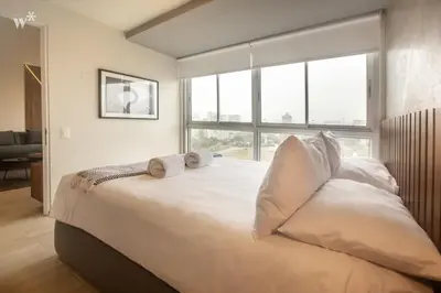 a bedroom with a large bed with two pillows on it at Pionero by Wynwood House in Lima