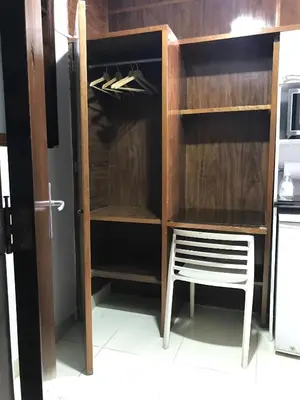 a wooden cabinet with a chair in a kitchen at Minidepartamento céntrico entre Lince y San Isidro in Lima