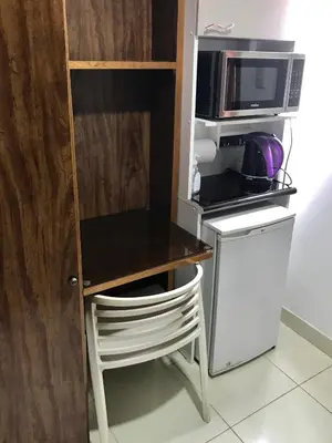 a small kitchen with a table and a microwave at Minidepartamento céntrico entre Lince y San Isidro in Lima