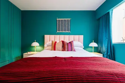 a bedroom with a large bed with a red blanket at ✶ Kotosh Residence ✶ LUXURY Best Location & Piano in Lima