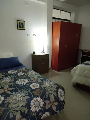 a bedroom with a bed and a dresser at Departamento con servicios incluidos, equipado in Lima