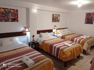 a hotel room with three beds in a room at DENNY'S MAPI in Machu Picchu