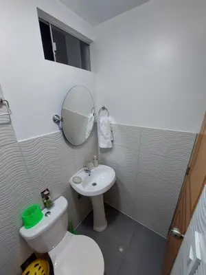 a bathroom with a sink and a toilet and a mirror at Casa Mahulu in Paracas