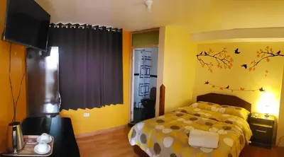 a bedroom with a bed and a tv in it at Nature Home Cusco in Cusco