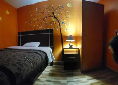 a bedroom with a bed and a tree with butterflies at Nature Home Cusco in Cusco