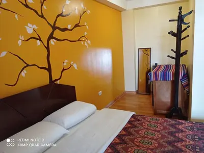 a bedroom with a bed with a tree mural on the wall at Nature Home Cusco in Cusco