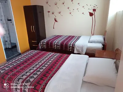 two beds in a room with flowers on the wall at Nature Home Cusco in Cusco