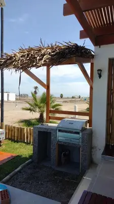 a patio with an outdoor grill with a view of the beach at Playa ChinchaHouse - Agradable casa de playa en Chinchaycamac in Chincha Baja